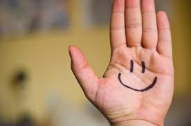 smile dłoń, na której narysowana jest uśmiechnięta buźka