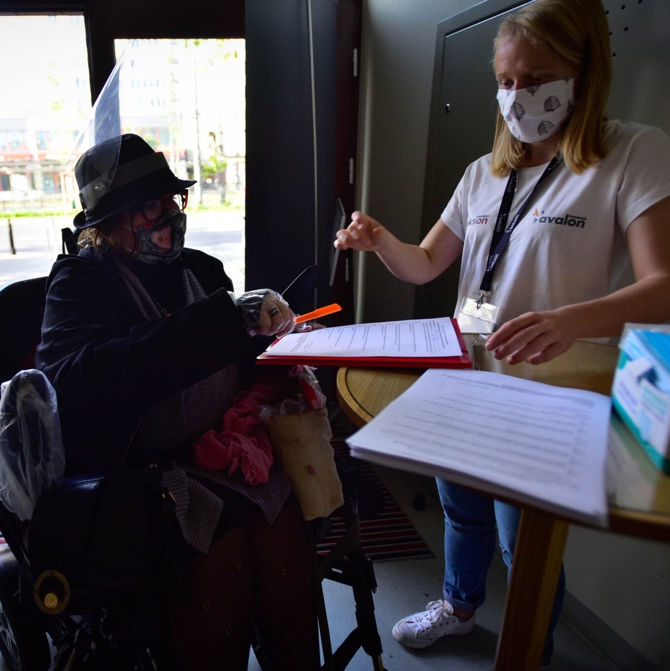 Na zdjęciu wolontariuszka na rejestracji podczas konferencji Sekson i kobieta na wózku.
