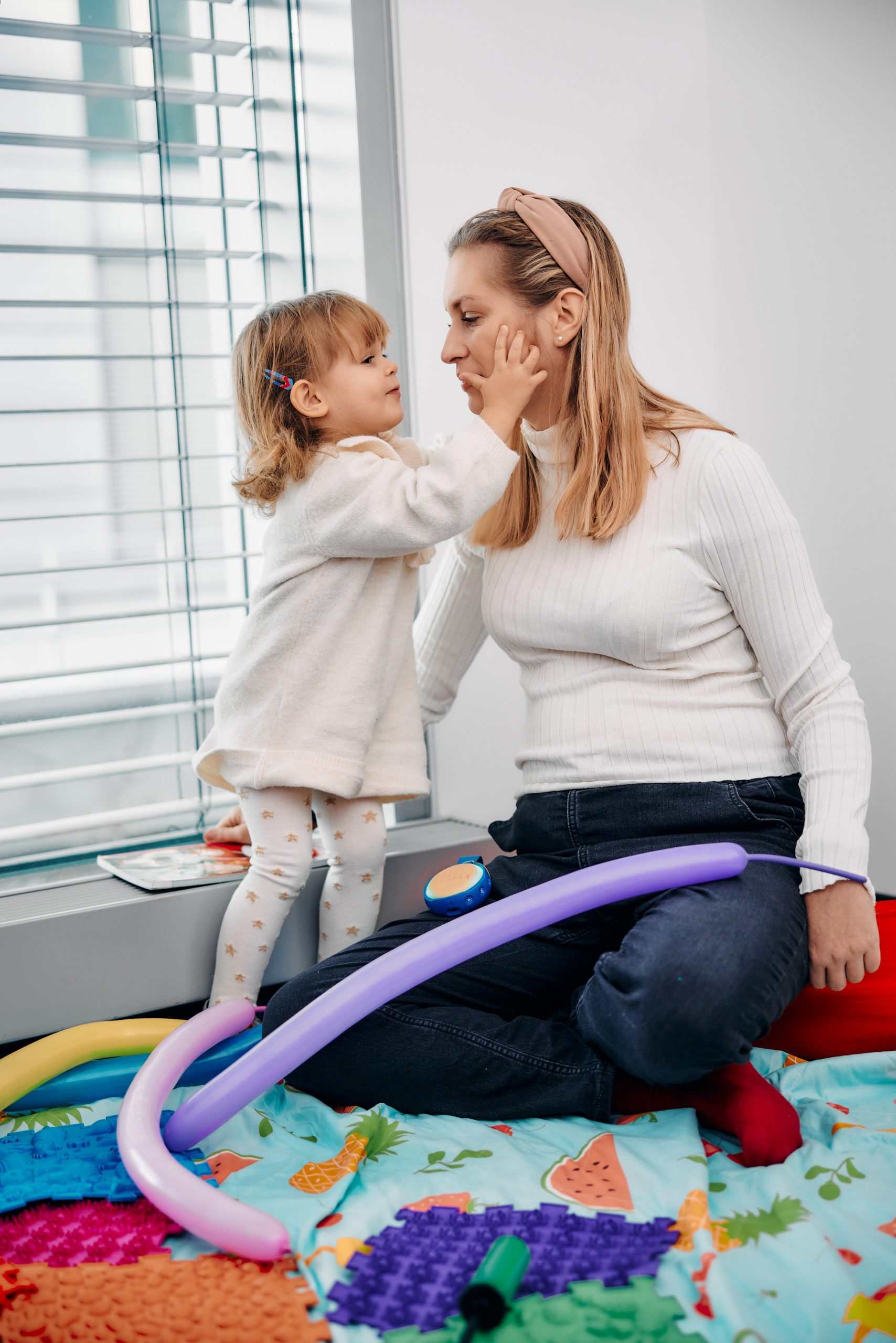 Mama z niepełnosprawnością bawi się ze swoją córką.