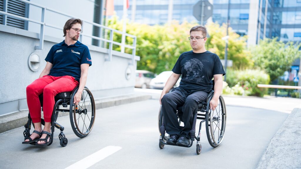 Pacjent i fizjoterapeuta na wózkach, zjeżdżają z wzniesienia.