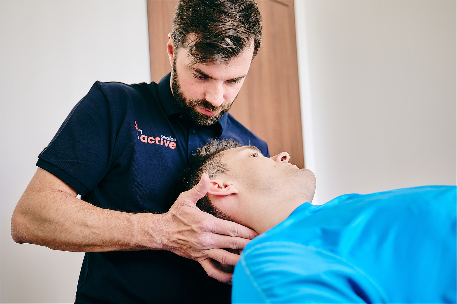 Na zdjęciu fizjoterapeuta rotuje głowę pacjenta w trakcie terapii czaszkowo-krzyżowej.