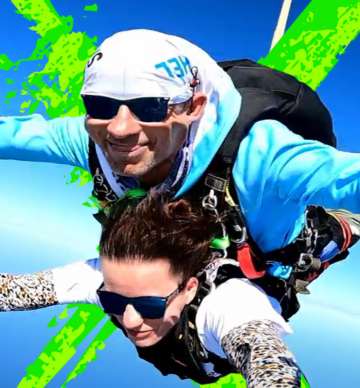Kobieta i mężczyzna skaczą ze spadochronem w tandemie.