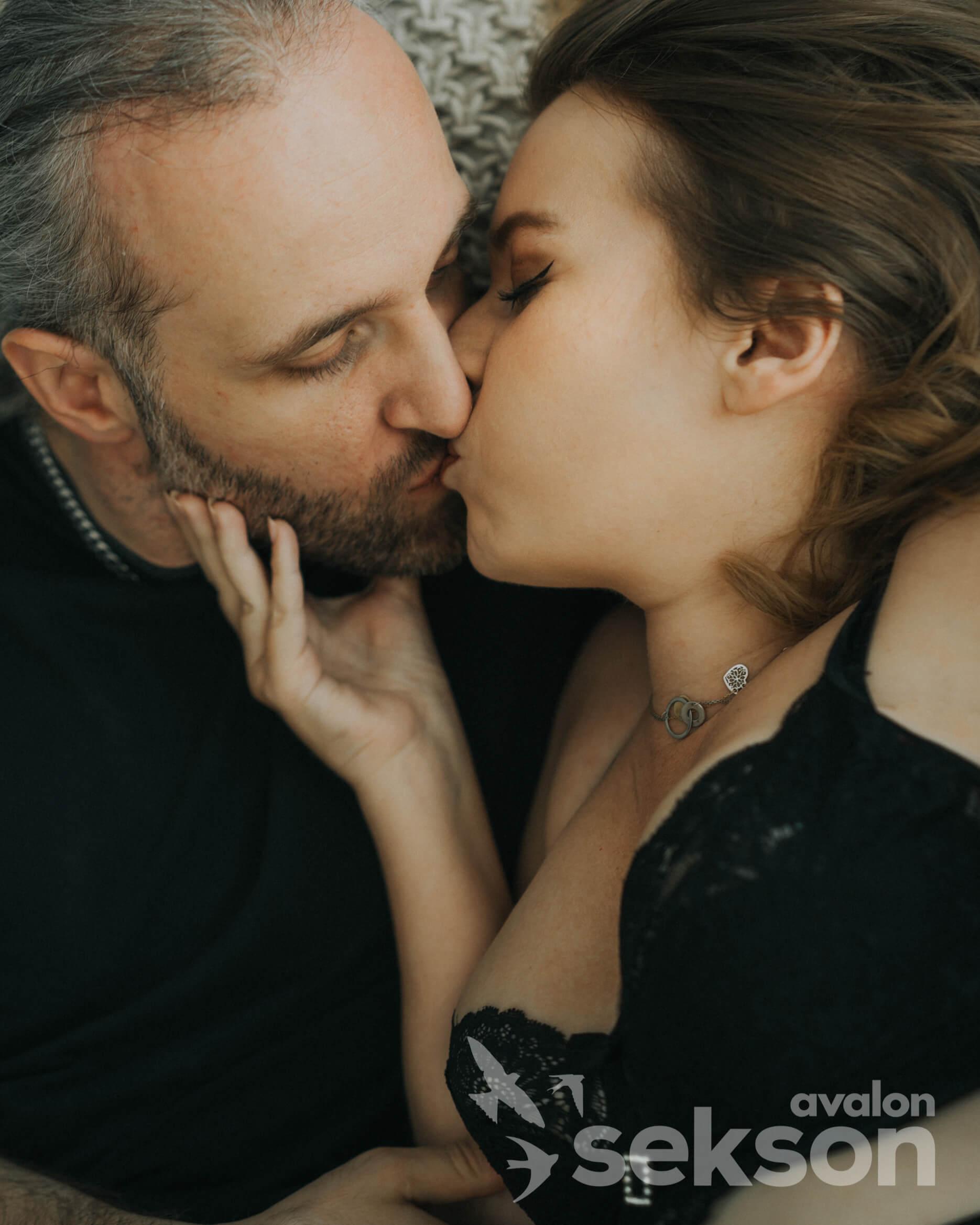 Zbliżenie na całującą się parę. Sylwia trzyma dłonią podbródek Marcina.