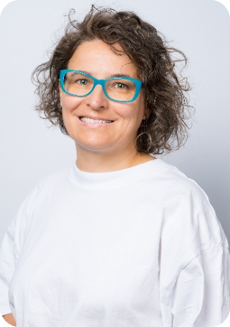 Ewa Lefik Babiasz w białej blizce i okularach z niebieskimi oprawkami.