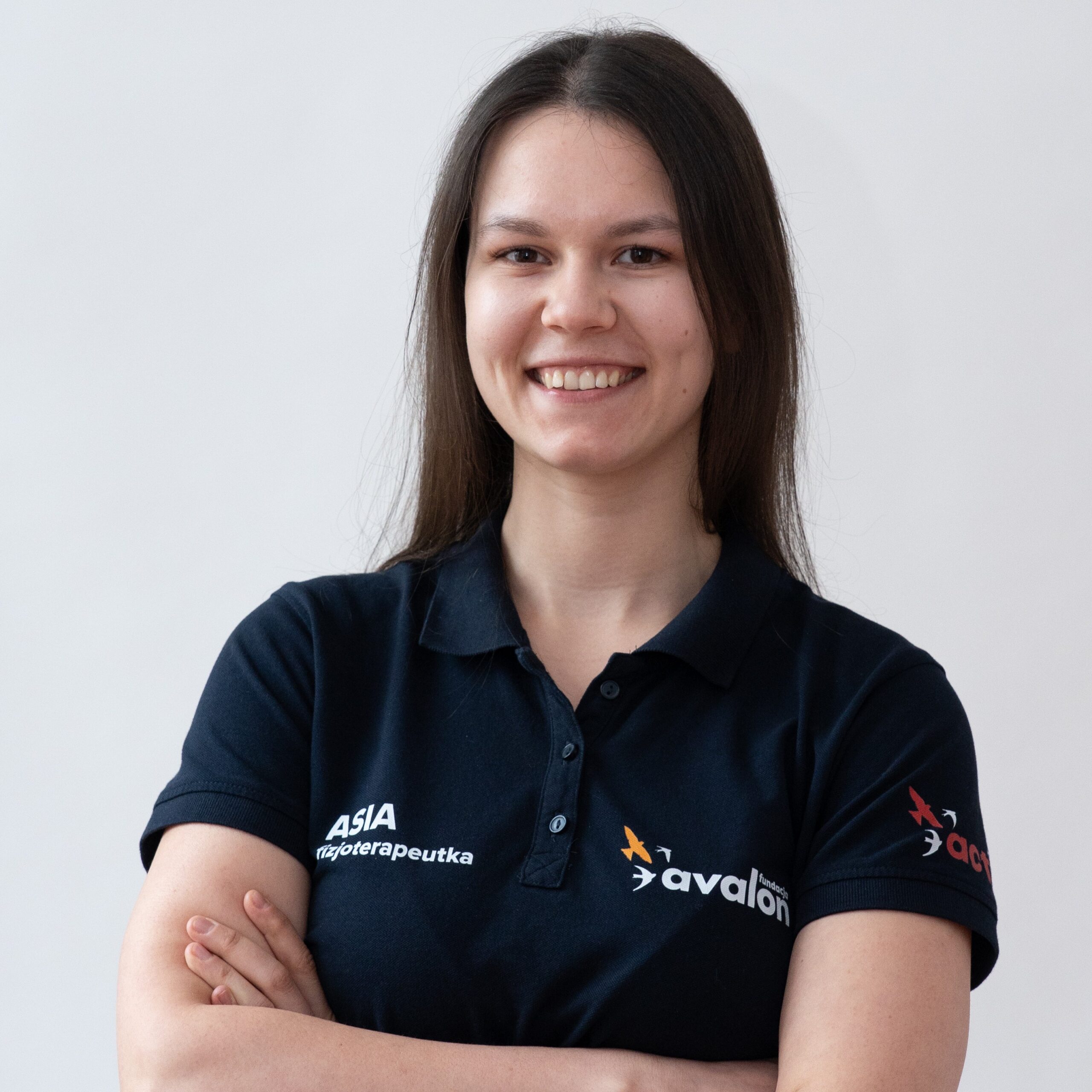 Uśmiechnięta Joanna Rusiecka w koszulce fizjoterapeuty Fundacji Avalon.