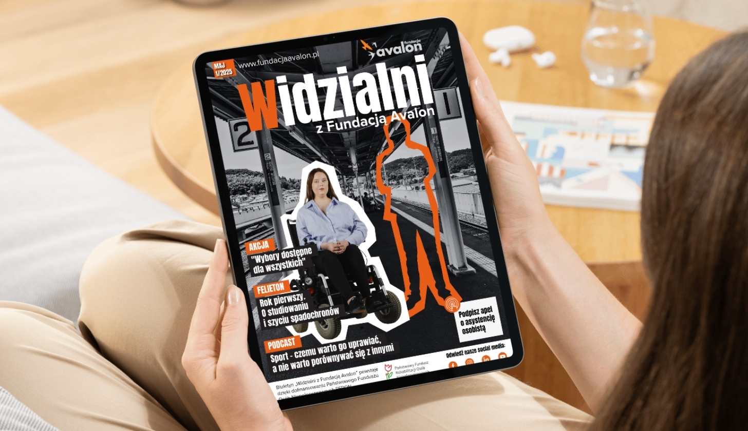 Kobieta trzyma w rekach tablet, na ekranie biuletyn Widzialni z Fundacją Avalon.