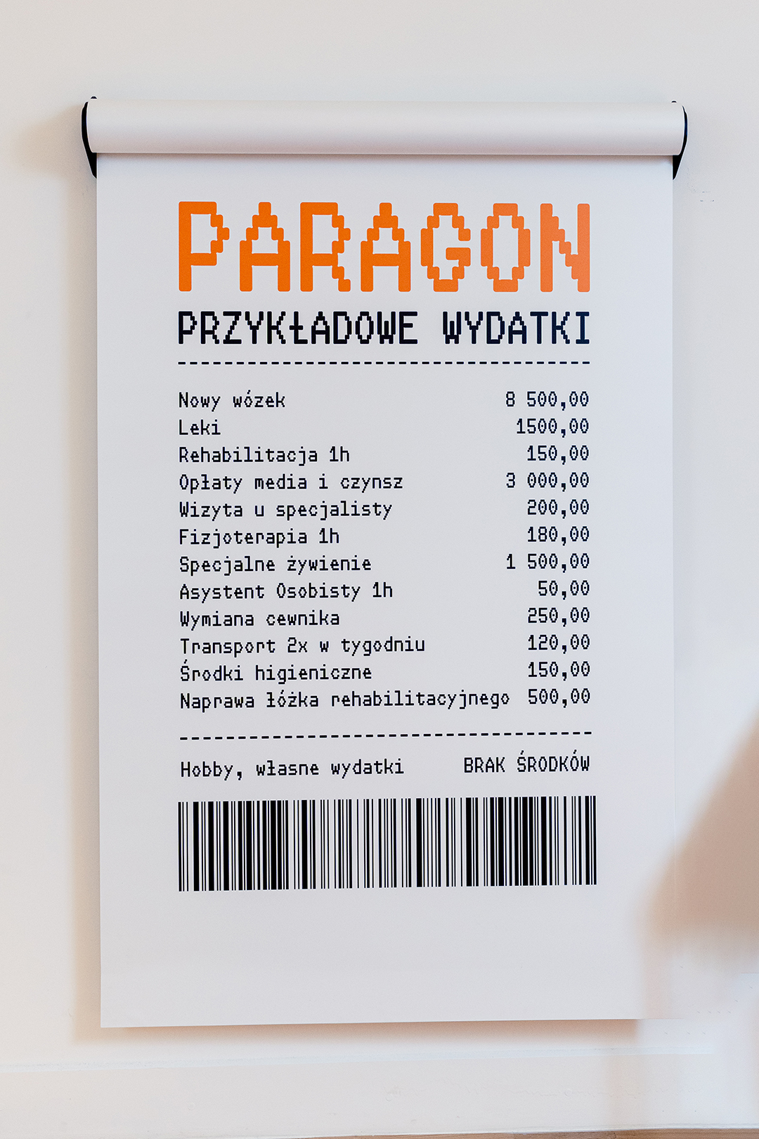 Symboliczny „Paragon grozy” obrazuje przykładowe wydatki osoby z niepełnosprawnością, która jak każdy obywatel musi mierzyć się z codziennymi kosztami życia, inflacją, podwyżkami cen, nieplanowanymi opłatami. A to tylko część wyzwań. Konieczność zakupu leków, specjalistycznego sprzętu, wsparcie rehabilitanta — to niezbędne wydatki, które powodują nieustanne problemy finansowe, a w konsekwencji brak możliwości prowadzenia bezpiecznego, stabilnego i godnego życia.