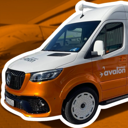 Pomarańczowo-biały bus z logotypem Fundacji Avalon, numerem KRS oraz ilustracjami przedstawiającymi osoby z różnymi niepełnosprawnościami.