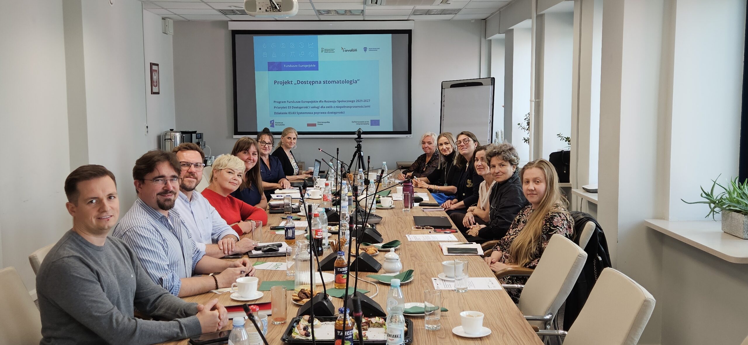 Eksperci projektu Dostępna stomatologia zgromadzeni wokó stołu w slai konferencyjnej.
