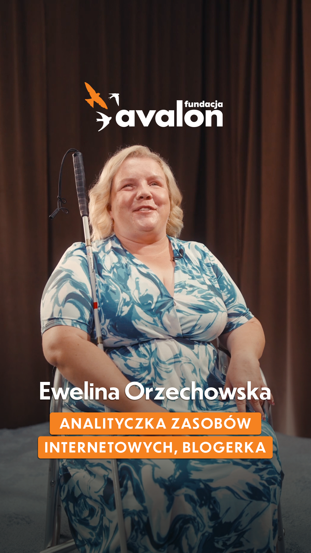 Ewelina w białoniebieskiej sukience, trzyma pod ręką białą laskę. Napis: Ewelina Orzechowska: Analityczka zasobów internetowych, blogerka.