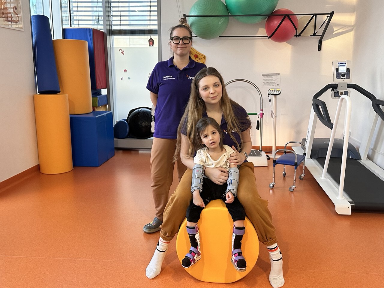 Dwie rehabilitantki i mała pacjentka - Laura w sali rehabilitacyjnej.
