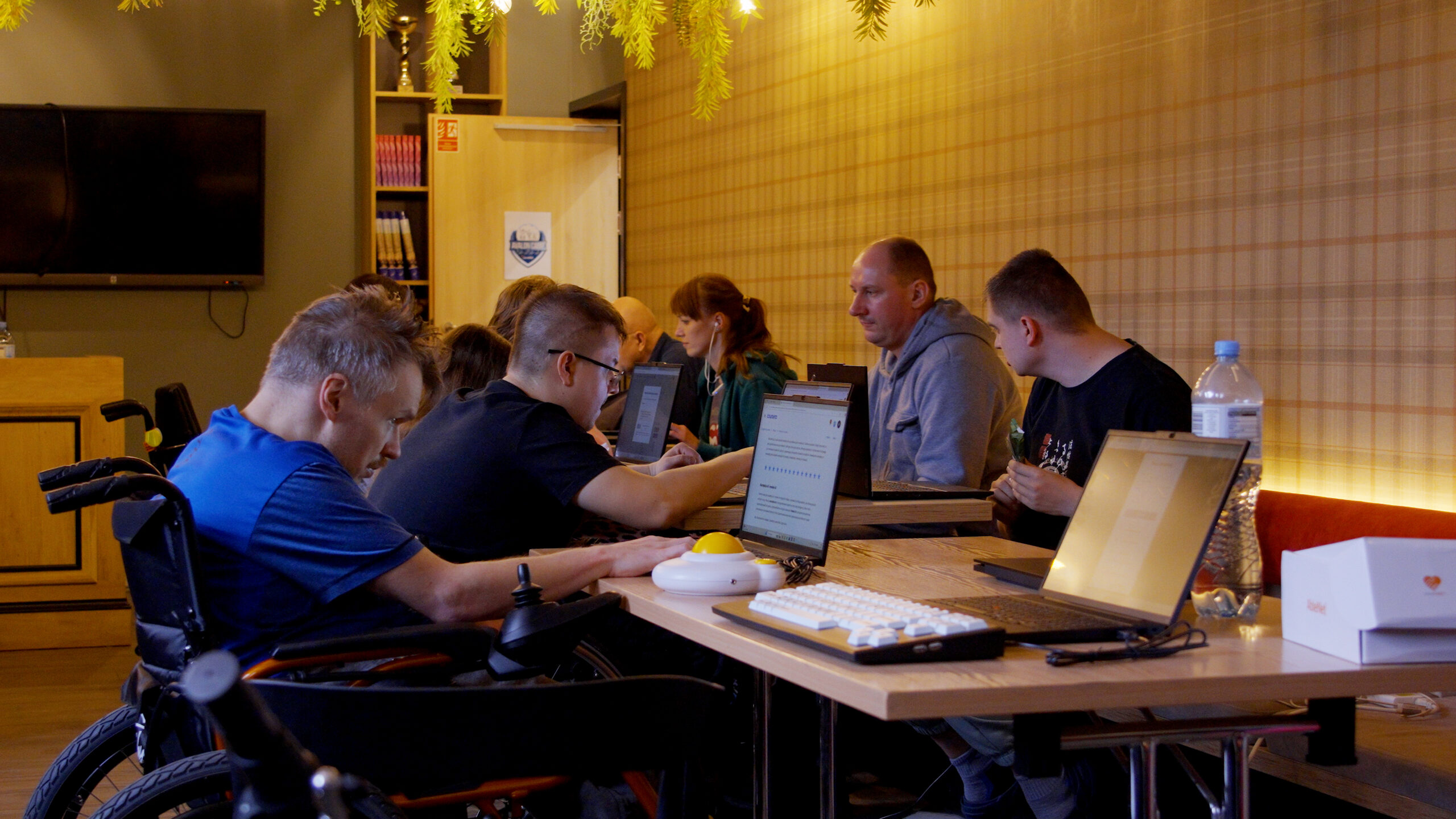 Grupa osób z niepełnosprawnościami podczas szkolenia przed komuterami.