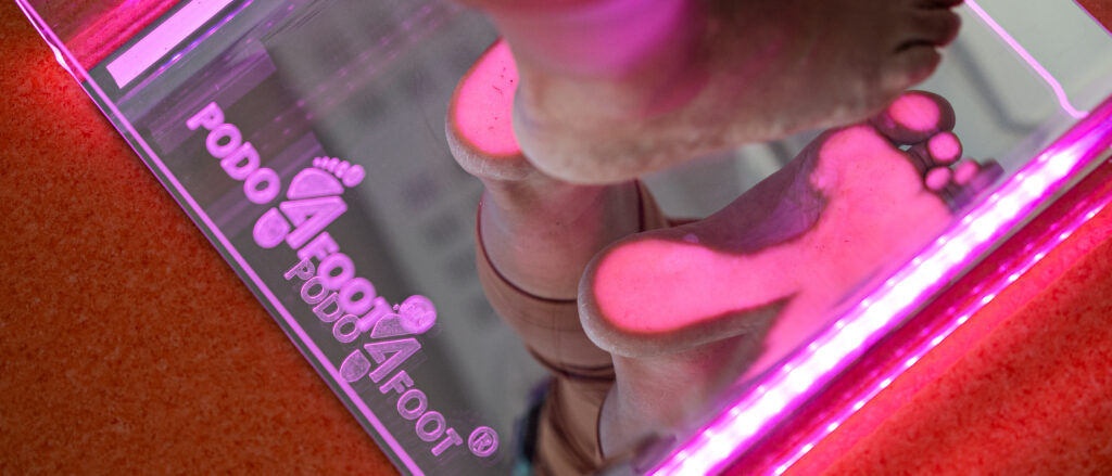 Osoba stoi bosymi stopami na urządzeniu.