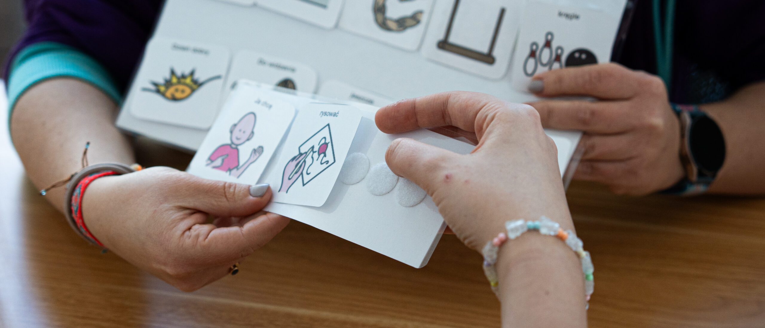 Osoba trzyma obrazki w dłoni.