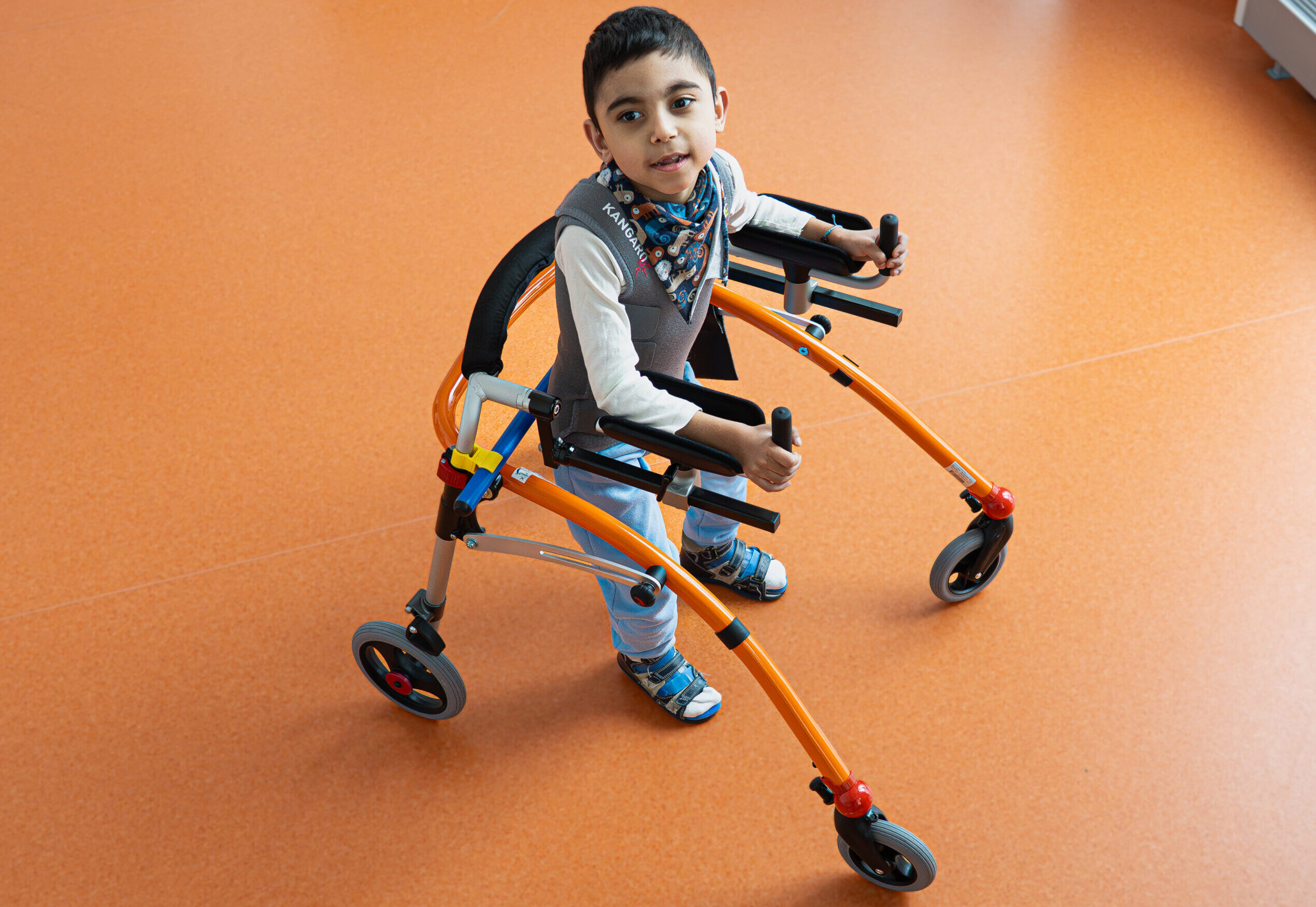 Chłopiec porusza się za pomocą chodzika.