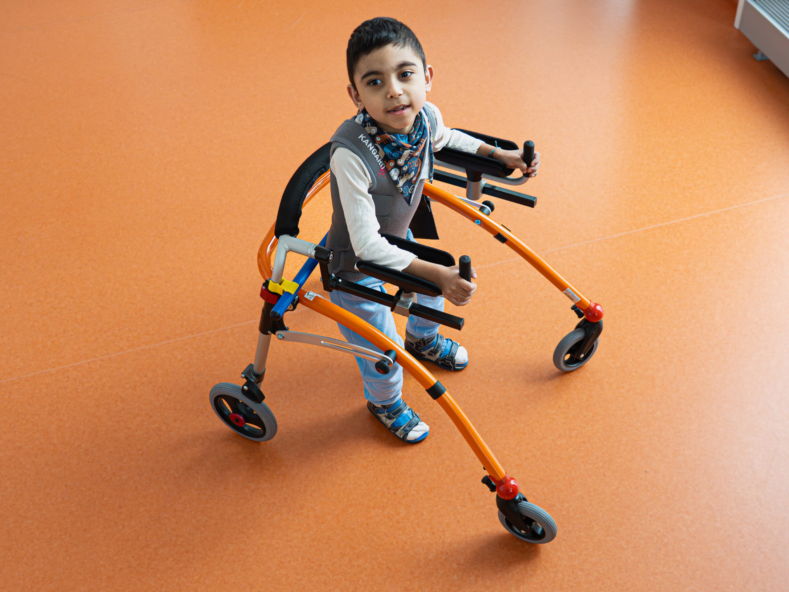 Chłopiec porusza się za pomocą chodzika.