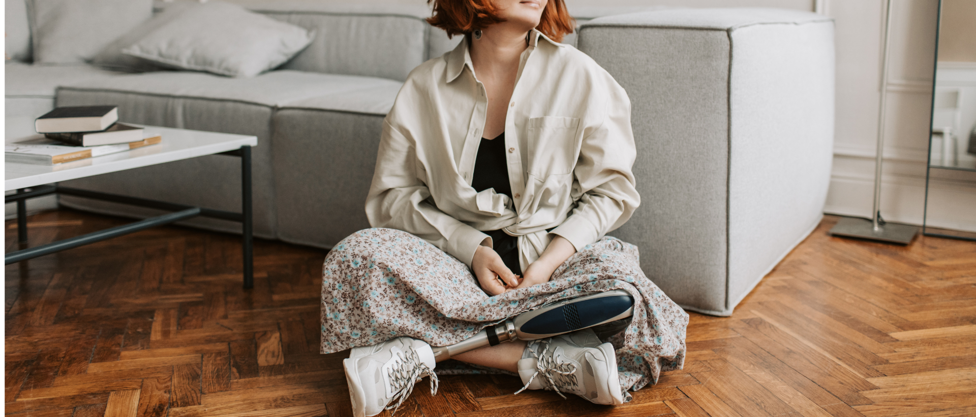 kobieta z protezą nogi siedząca na podłodze w salonie