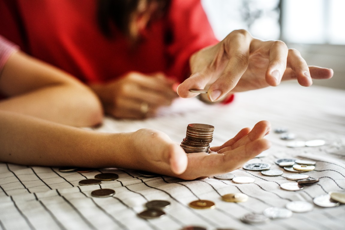 Jak zbierać środki z 1,5% podatku? Osoba na dłoni trzyma kilka monet