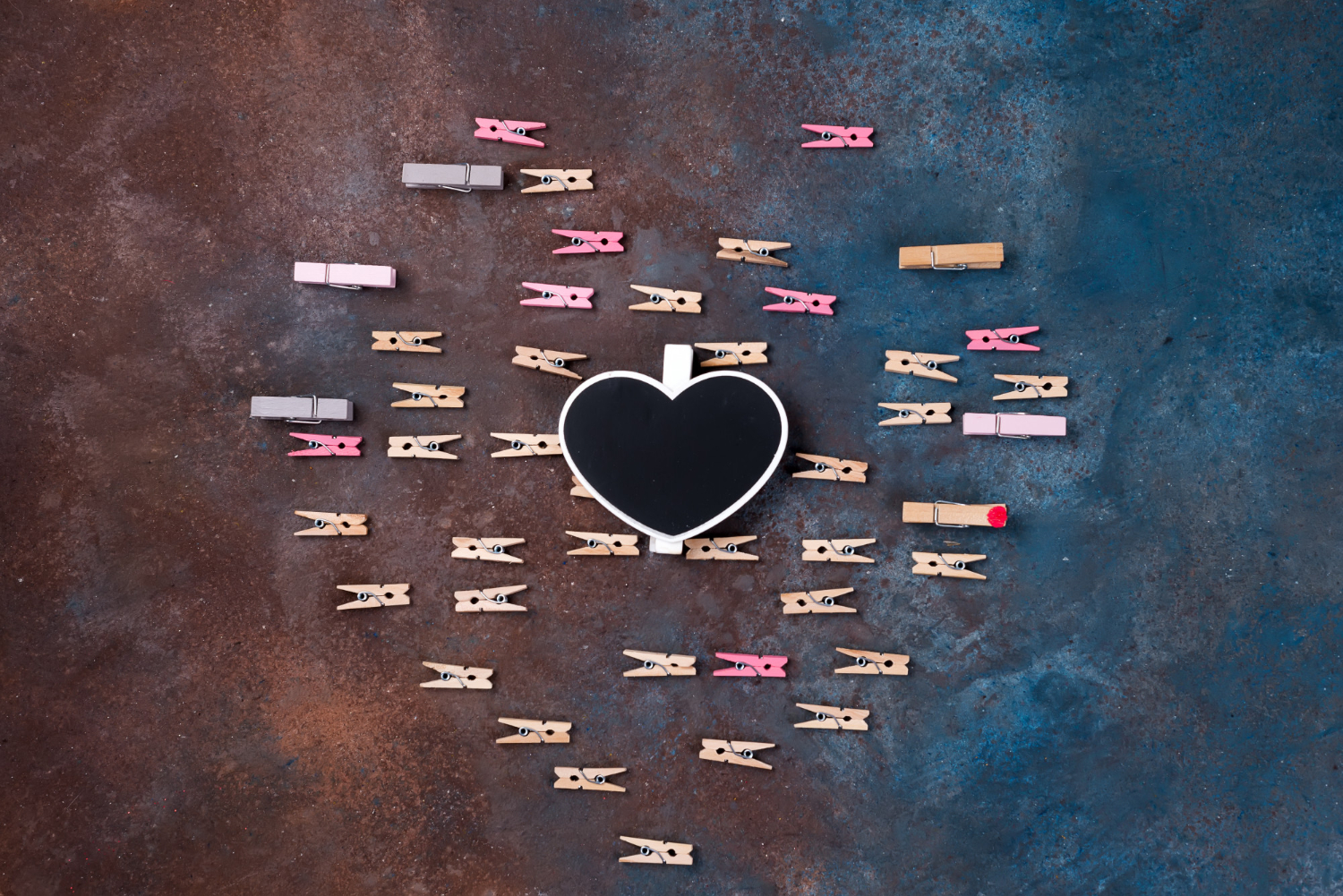 Widzimy serce, które jest ułożone z klamerek. W samym środku znajduje się czarne serce drewniane
