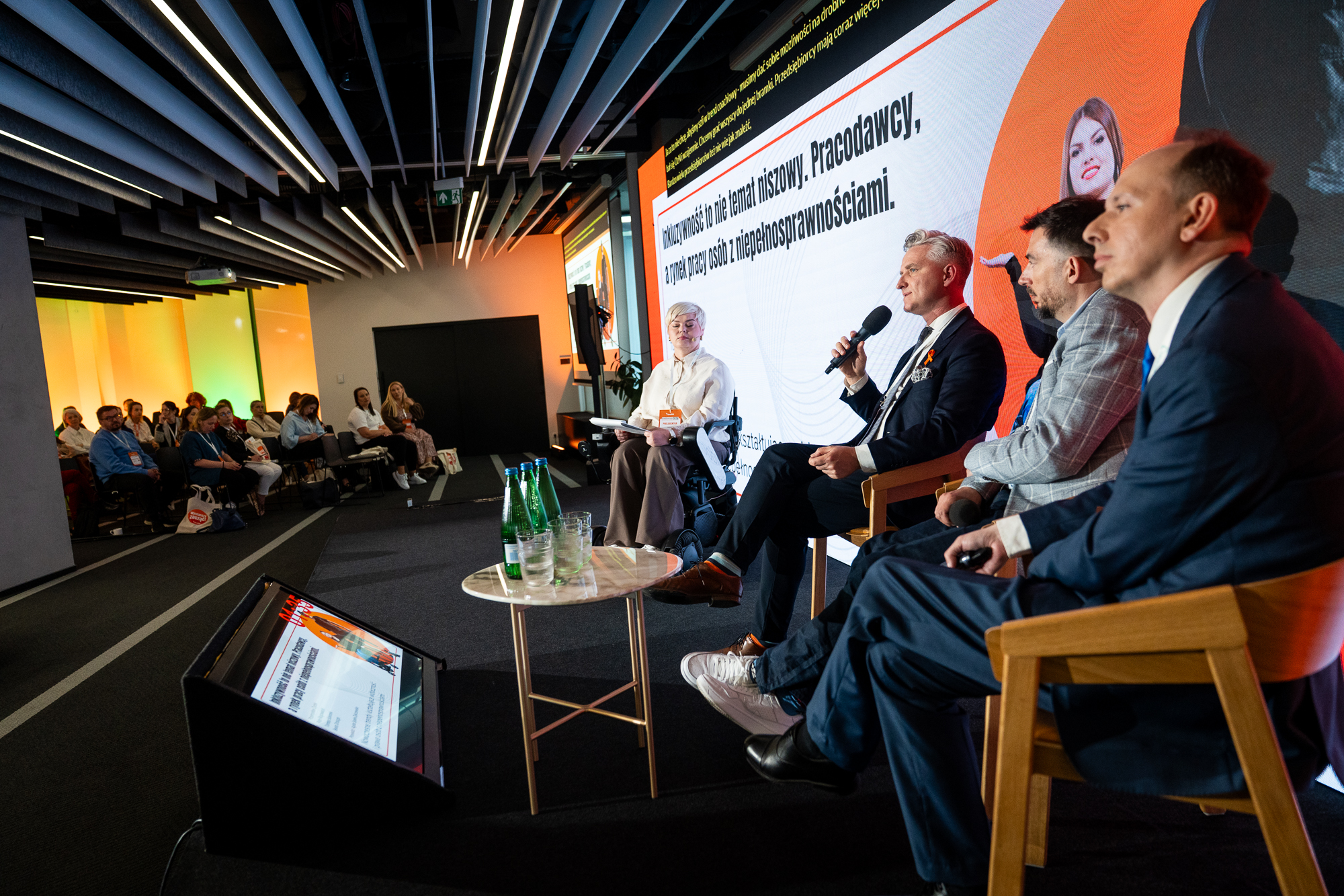 osoby siedzące prowadzą rozmowę podczas konferencji