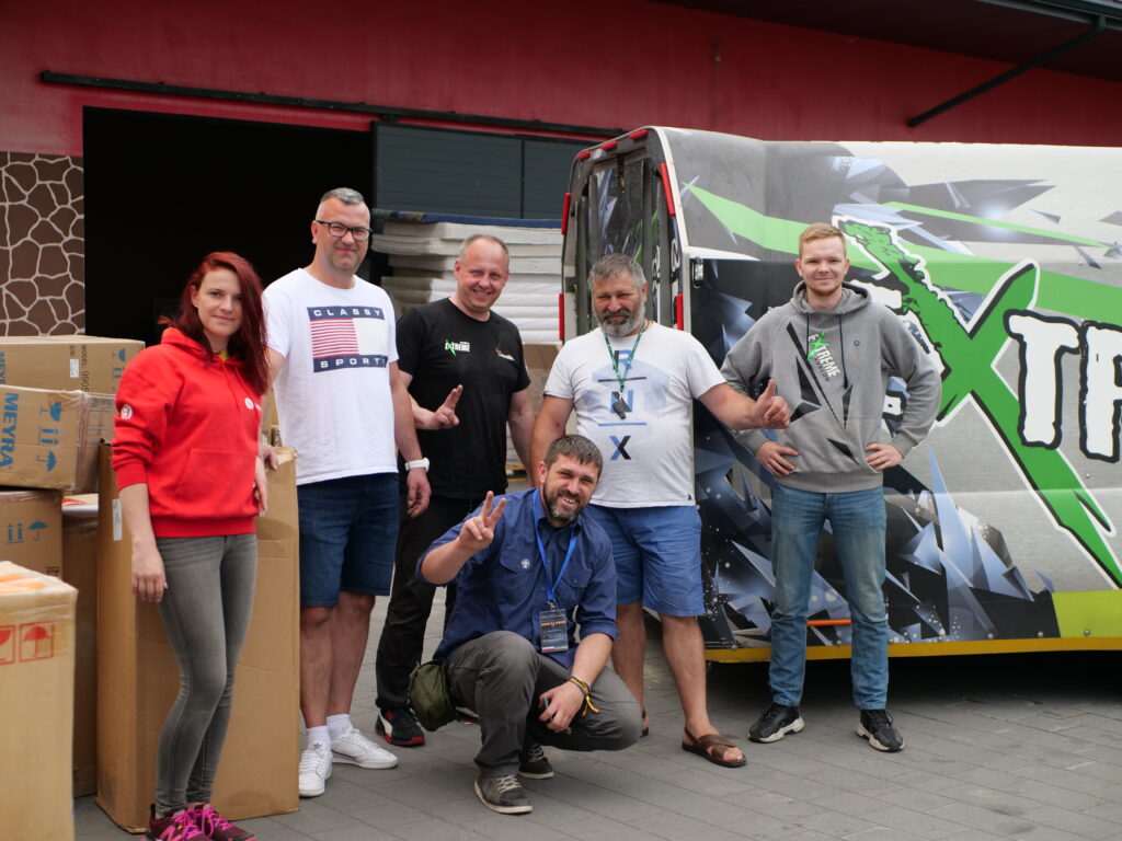 grupa osób stojąca przy samochodzie fundacji awalon